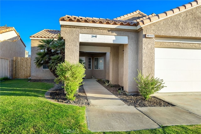 entrance to property featuring a garage and a yard