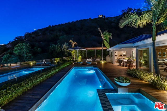 view of pool with a deck and an in ground hot tub