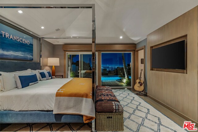 bedroom featuring lofted ceiling and access to outside