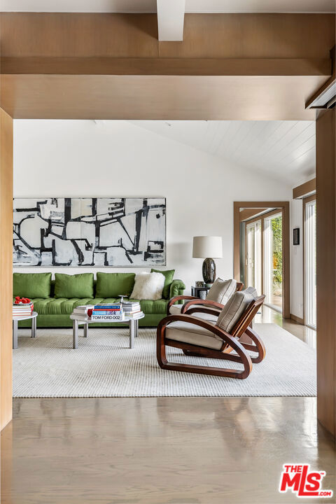 living room with vaulted ceiling with beams