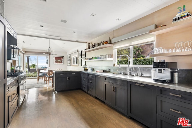 kitchen featuring vaulted ceiling, dark hardwood / wood-style flooring, sink, and high end range