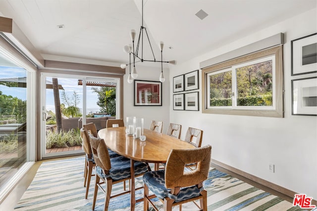 dining room featuring lofted ceiling, light wood-type flooring, and a chandelier