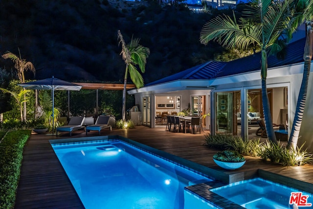 view of swimming pool with a deck and an in ground hot tub