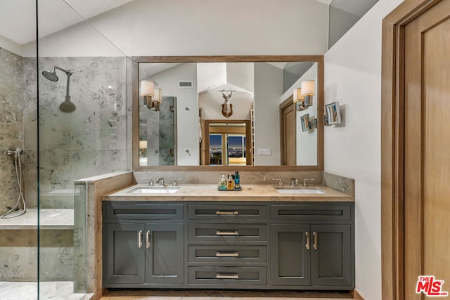 bathroom with lofted ceiling, vanity, and a tile shower