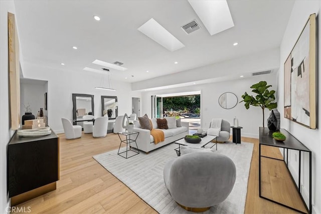 living room featuring a skylight and light hardwood / wood-style floors