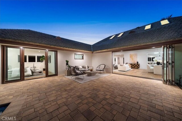 patio terrace at dusk featuring outdoor lounge area