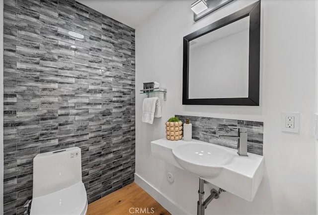 bathroom featuring toilet, hardwood / wood-style floors, and sink