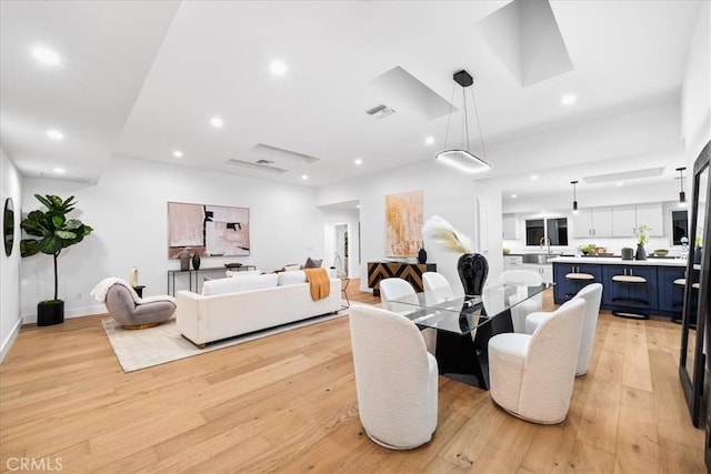 living room with sink and light hardwood / wood-style flooring