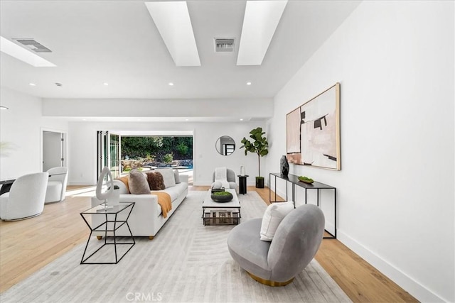 living room featuring a skylight and light wood-type flooring