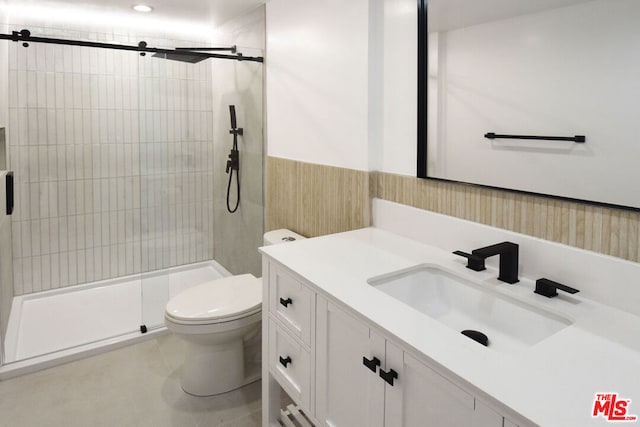 bathroom featuring a shower with shower door, vanity, and toilet