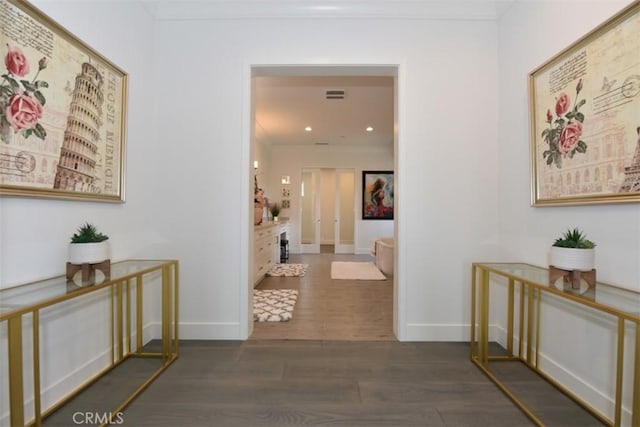 hallway featuring ornamental molding and dark hardwood / wood-style floors