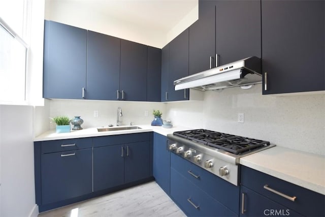 kitchen with sink, stainless steel gas stovetop, blue cabinetry, and tasteful backsplash