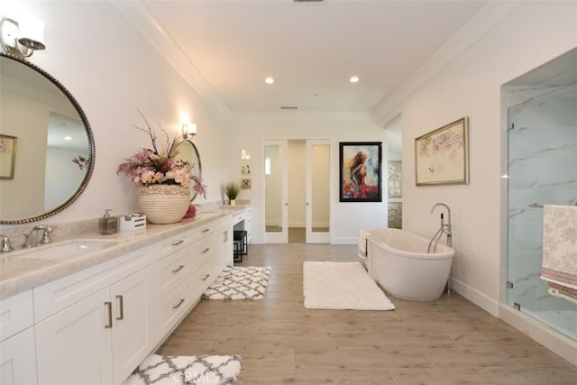 bathroom with vanity, wood-type flooring, crown molding, and plus walk in shower