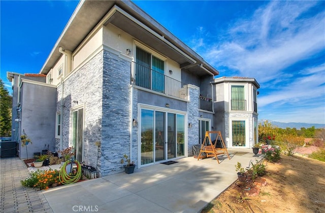 rear view of property featuring a patio area and central AC