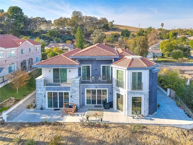 back of property with a balcony and a patio