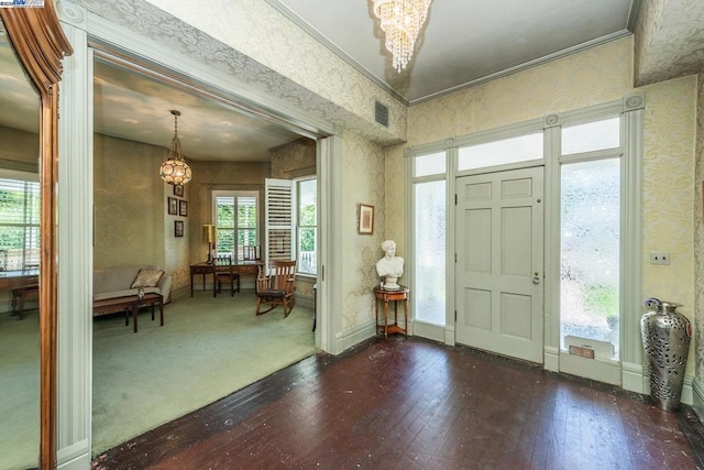 foyer entrance with dark hardwood / wood-style flooring, a chandelier, and ornamental molding