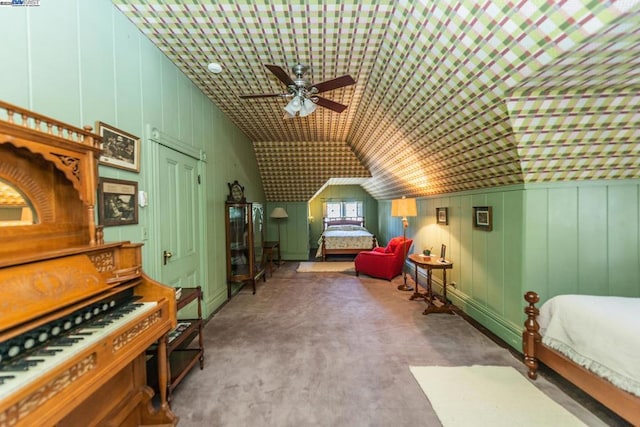 bedroom featuring ceiling fan, wood walls, and vaulted ceiling