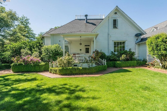 back of house featuring a lawn and a porch