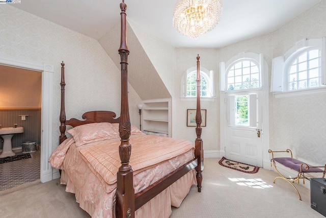 carpeted bedroom featuring an inviting chandelier and multiple windows