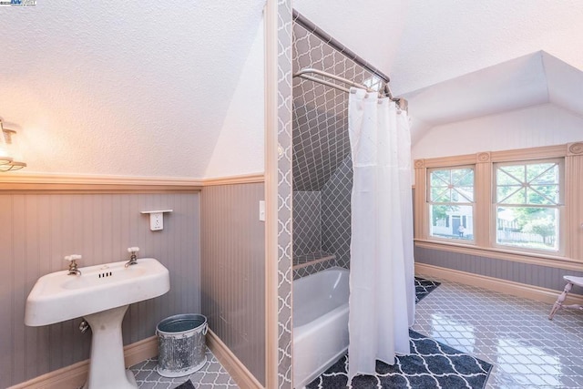 bathroom featuring lofted ceiling, tile patterned floors, shower / bath combo, and wood walls