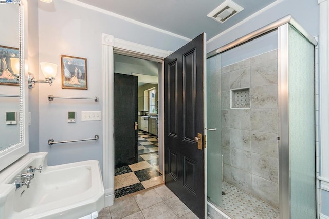 bathroom featuring tile patterned flooring, a shower with shower door, and sink