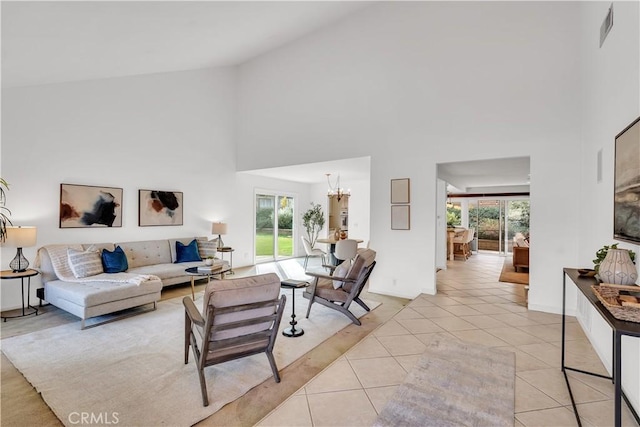 tiled living room with high vaulted ceiling and an inviting chandelier