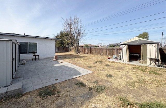 view of yard featuring a storage shed and a patio