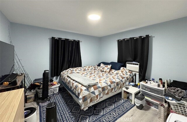 bedroom with cooling unit and hardwood / wood-style flooring