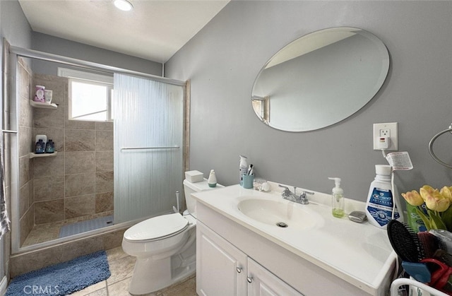 bathroom with tile patterned flooring, vanity, an enclosed shower, and toilet