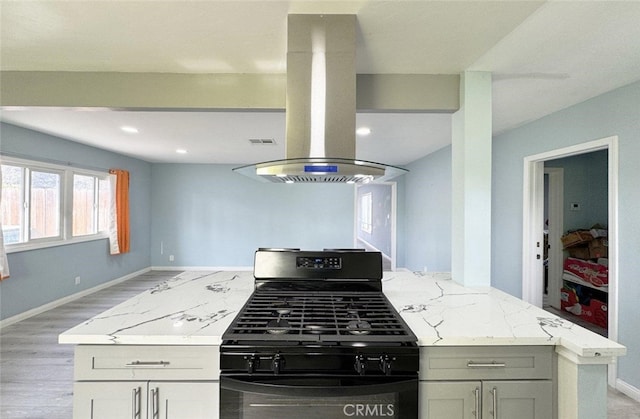 kitchen with white cabinetry, light wood-type flooring, light stone countertops, black range with gas stovetop, and island exhaust hood