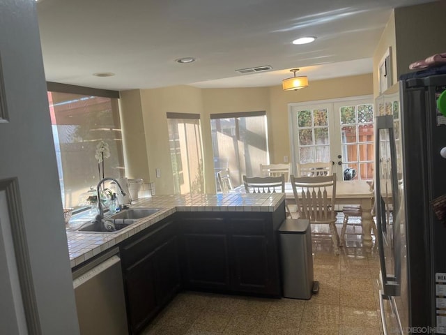 kitchen with french doors, appliances with stainless steel finishes, sink, and tile countertops