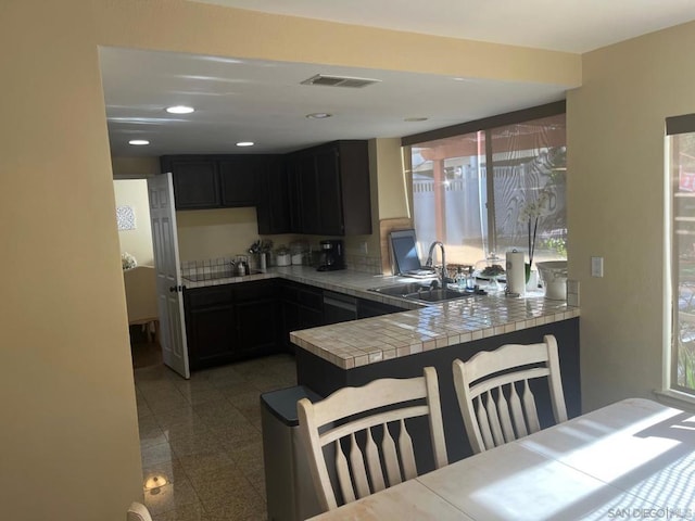 kitchen featuring a wealth of natural light, sink, tile countertops, and black electric stovetop