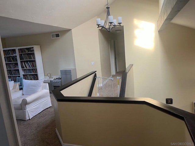 stairway featuring carpet, lofted ceiling, and a notable chandelier