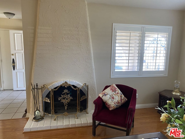 living area with tile patterned flooring and a brick fireplace