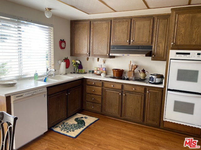 kitchen with sink, white appliances, and light wood-type flooring