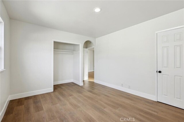 unfurnished bedroom with a closet and light hardwood / wood-style floors