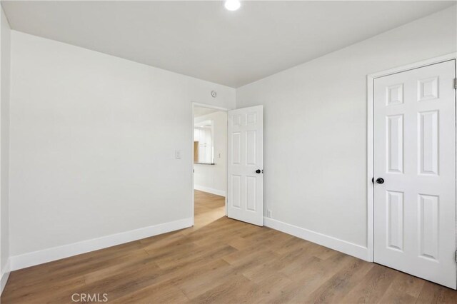 unfurnished bedroom featuring light wood-type flooring and a closet