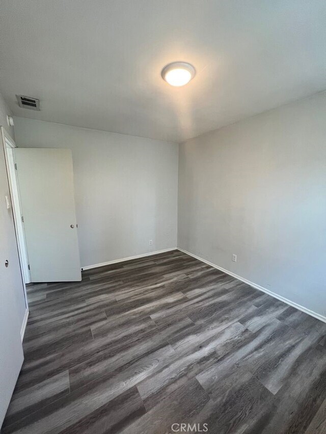 empty room with dark hardwood / wood-style floors