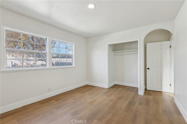 unfurnished bedroom with a closet and light hardwood / wood-style flooring