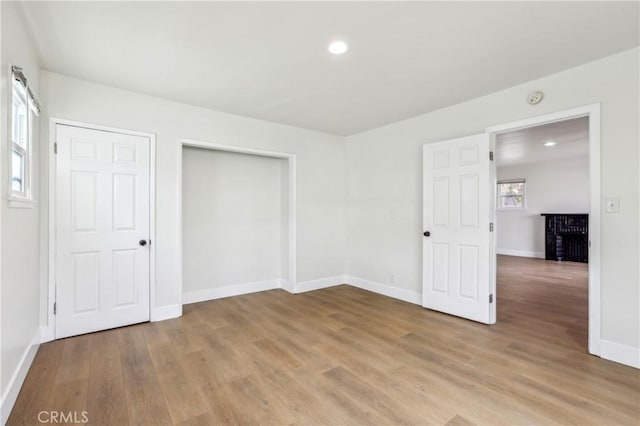 unfurnished bedroom featuring light hardwood / wood-style flooring and a closet