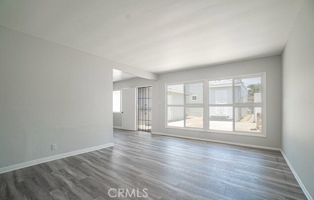 spare room featuring dark wood-type flooring and plenty of natural light