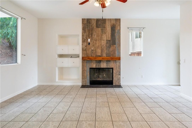 unfurnished living room with ceiling fan and a fireplace