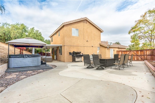 rear view of house with a patio area and a hot tub