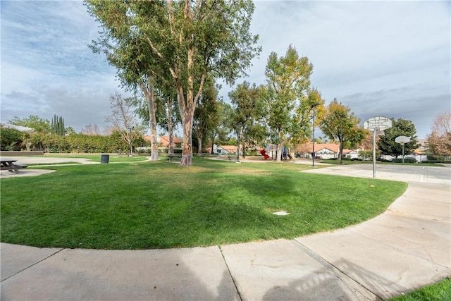 view of home's community with a yard and basketball court