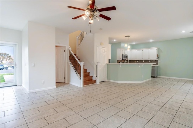 unfurnished living room featuring ceiling fan and light tile patterned floors