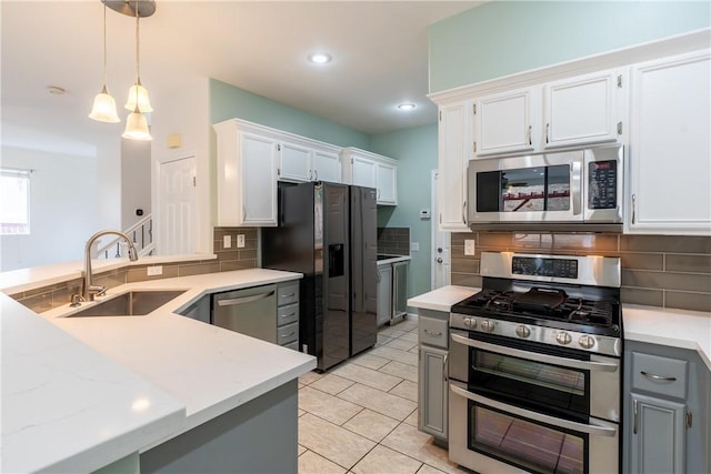 kitchen featuring white cabinets, sink, stainless steel appliances, and pendant lighting