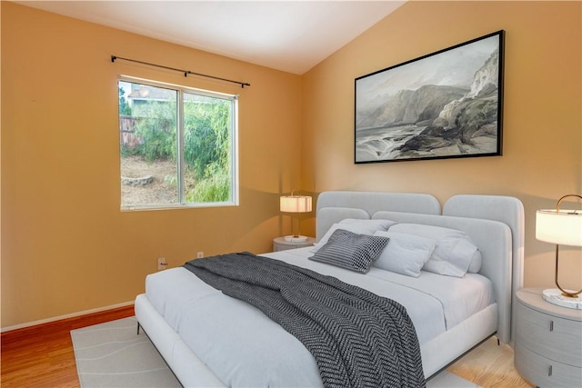 bedroom featuring light wood-type flooring and lofted ceiling