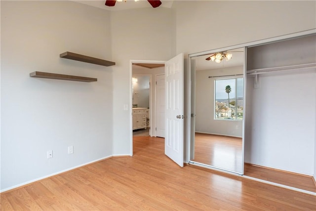 unfurnished bedroom featuring ceiling fan, a closet, and light wood-type flooring