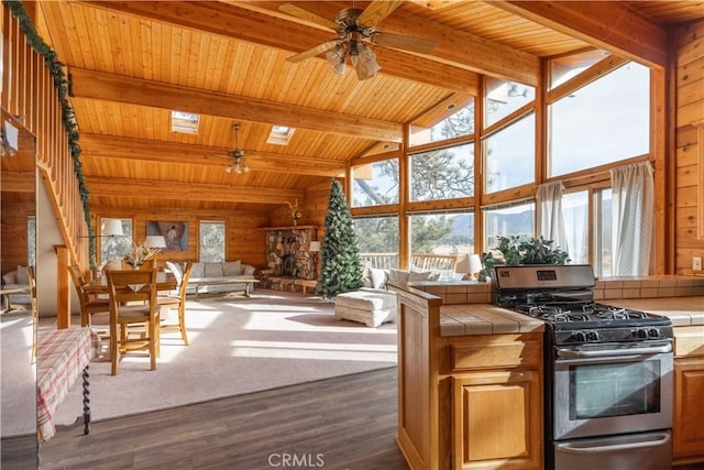 kitchen featuring tile counters, a wealth of natural light, and stainless steel range with gas stovetop