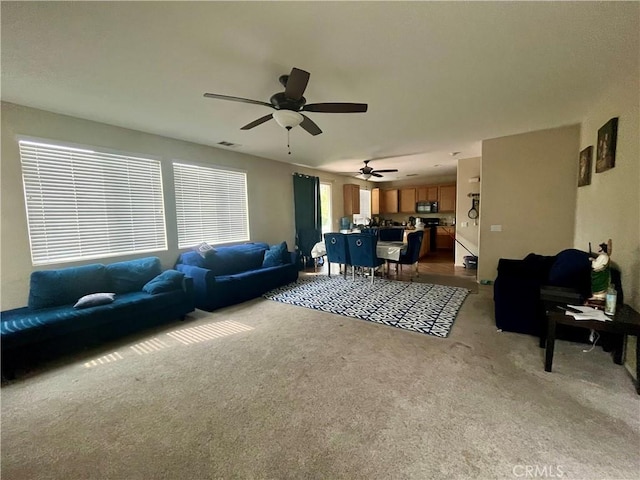 living room featuring ceiling fan and light colored carpet